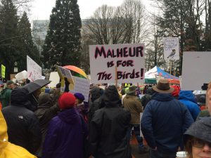 Crowd rallying, one sign reading "Malheur is for the birds"